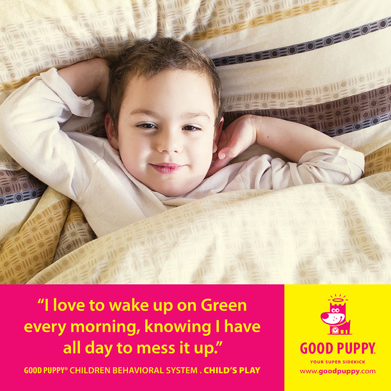 ChatGPT The image shows a young child lying in bed with a content expression. The child is covered with a patterned blanket. Below the image, a yellow and pink section features the text: "I love to wake up on Green every morning, knowing I have all day to mess it up." It also mentions "GOOD PUPPY® CHILDREN BEHAVIORAL SYSTEM. CHILD'S PLAY" and provides the website "www.goodpuppy.com." The Good Puppy logo and character are displayed on the right side.