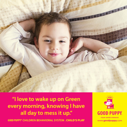 ChatGPT  The image shows a young child lying in bed with a content expression. The child is covered with a patterned blanket. Below the image, a yellow and pink section features the text: "I love to wake up on Green every morning, knowing I have all day to mess it up." It also mentions "GOOD PUPPY® CHILDREN BEHAVIORAL SYSTEM. CHILD'S PLAY" and provides the website "www.goodpuppy.com." The Good Puppy logo and character are displayed on the right side.