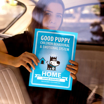 The image shows a person sitting in a car, holding a blue poster for the "Good Puppy Children Behavioral & Emotional System." The poster features a cartoon dog with a halo and a clock collar, along with text promoting the "HOME SUPER SIDEKICK" system for children aged 3 to 9 years old. The person's face is partially obscured by the window reflection.