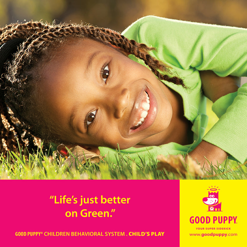 A smiling child lies on the grass, wearing a green shirt. The caption reads: "Life's just better on Green." This is part of the Good Puppy Children Behavioral System labeled "Child’s Play," with the Good Puppy logo and website link at the bottom right.