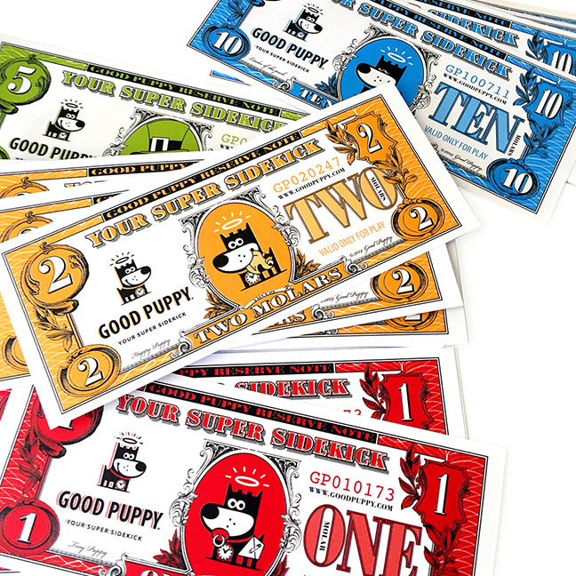 The image displays colorful play money from the Good Puppy system. The denominations include 1, 2, 5, and 10, each labeled "Your Super Sidekick" and featuring the Good Puppy character. The play money is designed to help children understand behavior management and rewards. The bills are color-coded: red for 1, orange for 2, green for 5, and blue for 10, each with engaging and playful designs.